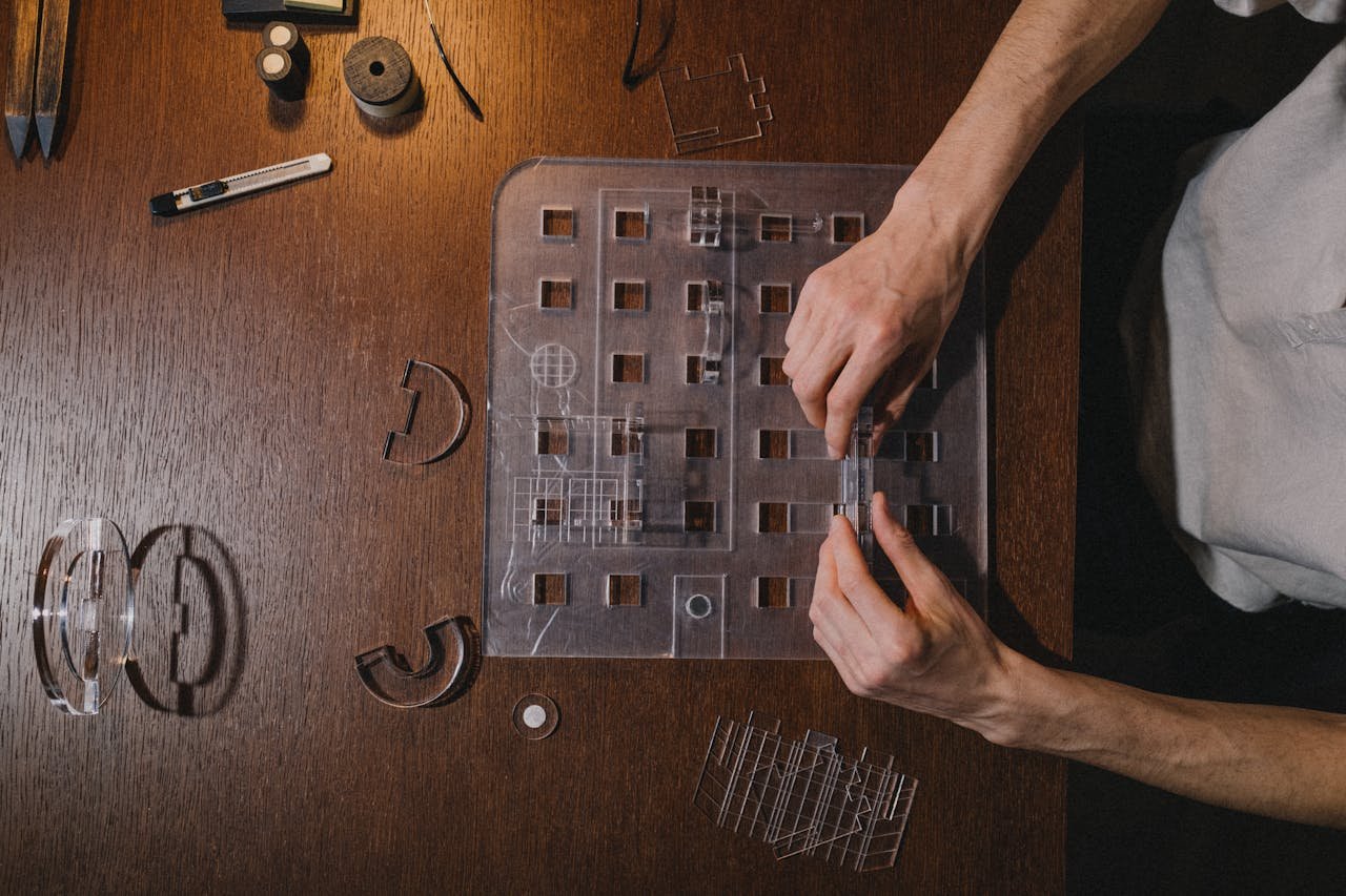 Architect creating a model on a wooden desk, showcasing creativity and design skills.